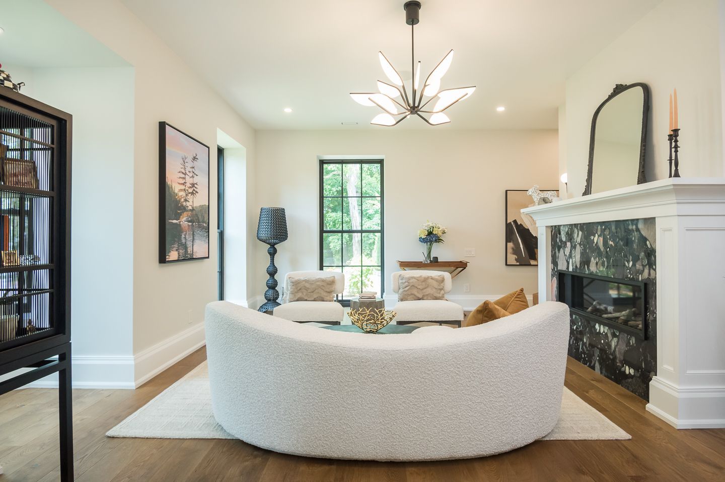 A living room with a round couch and a fireplace.