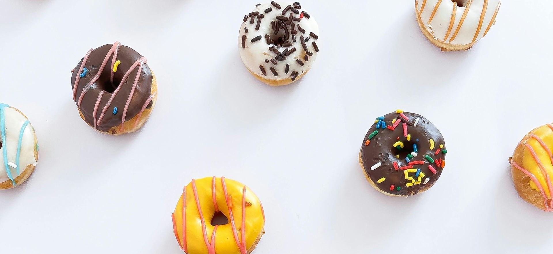 There are many different types of donuts on a white background.