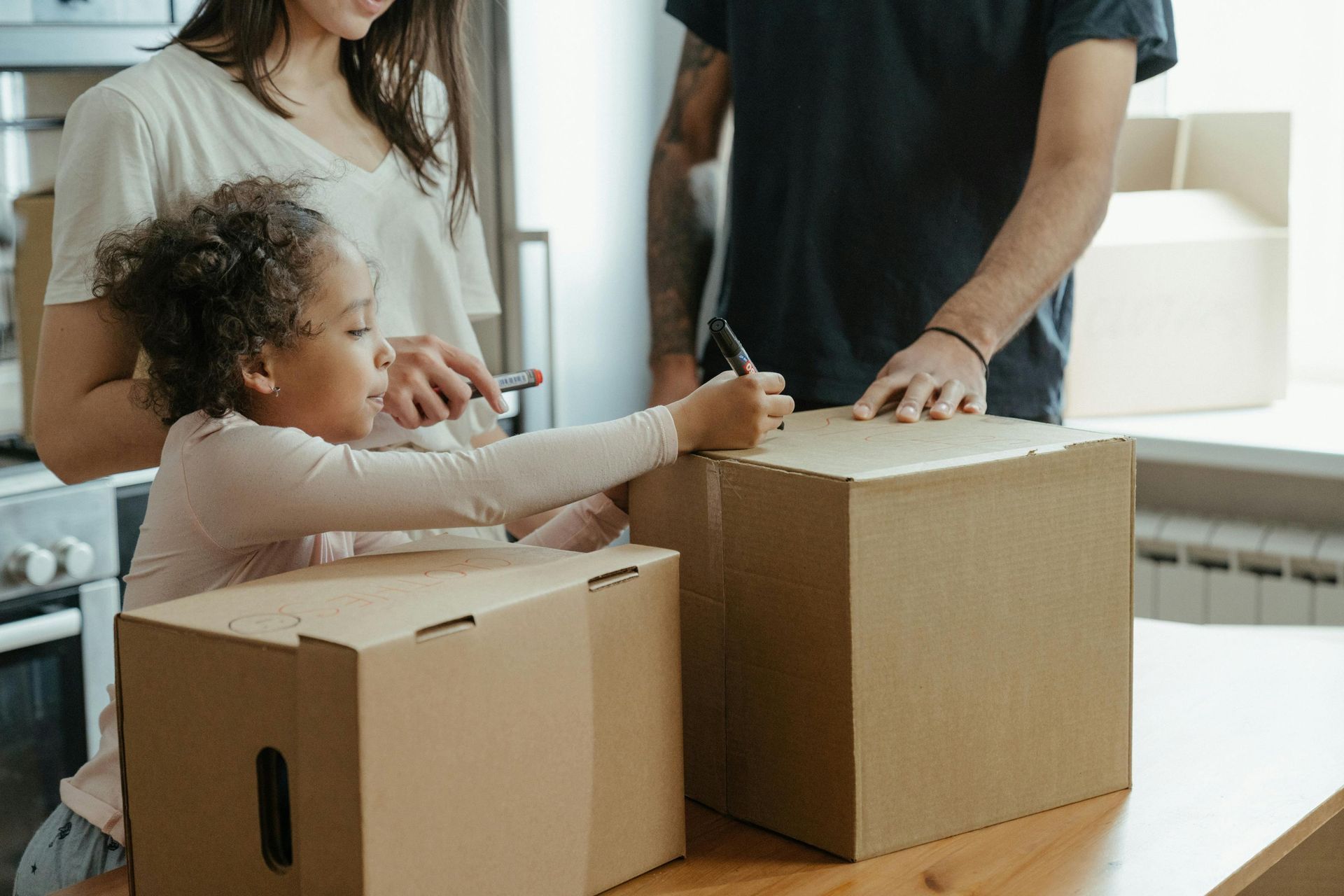 Family packing moving boxes together inside a home.