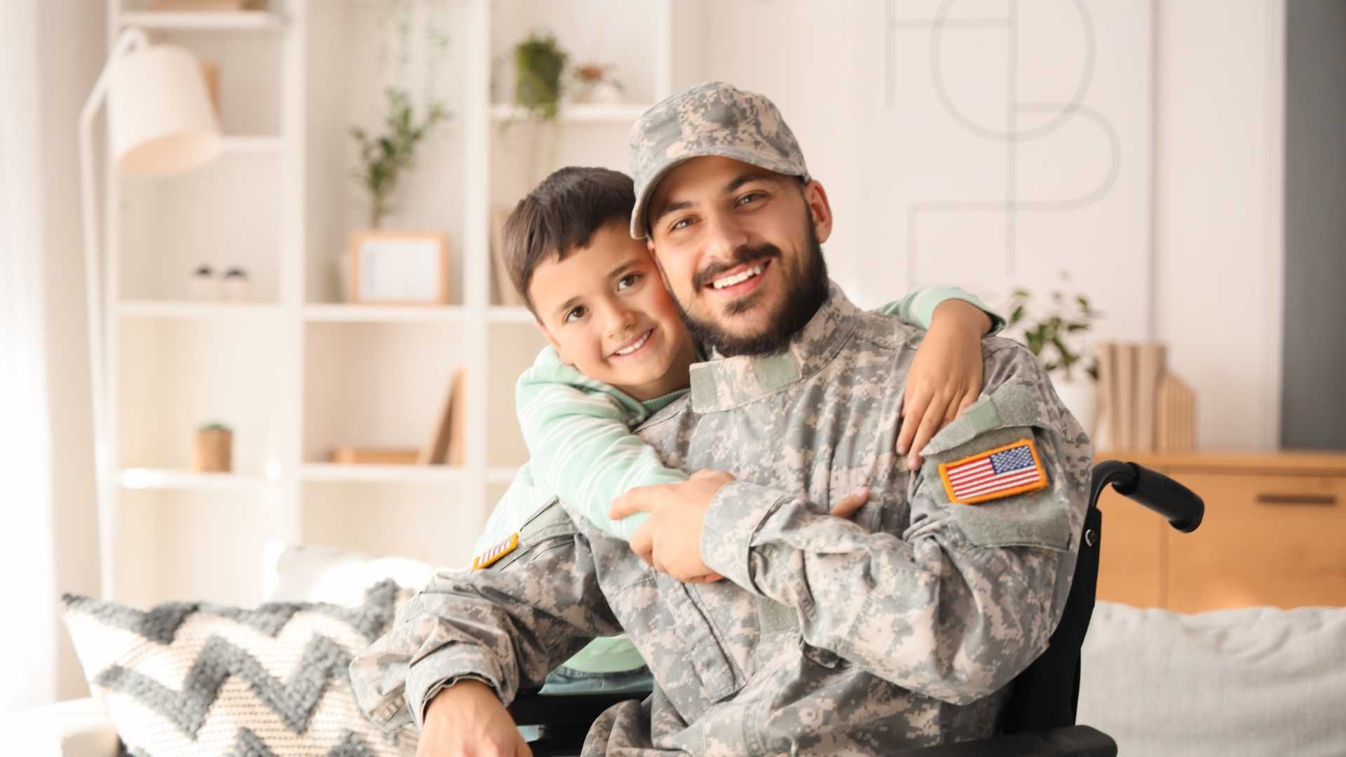 A soldier in camouflage hugging a smiling child on a couch in a bright living room.