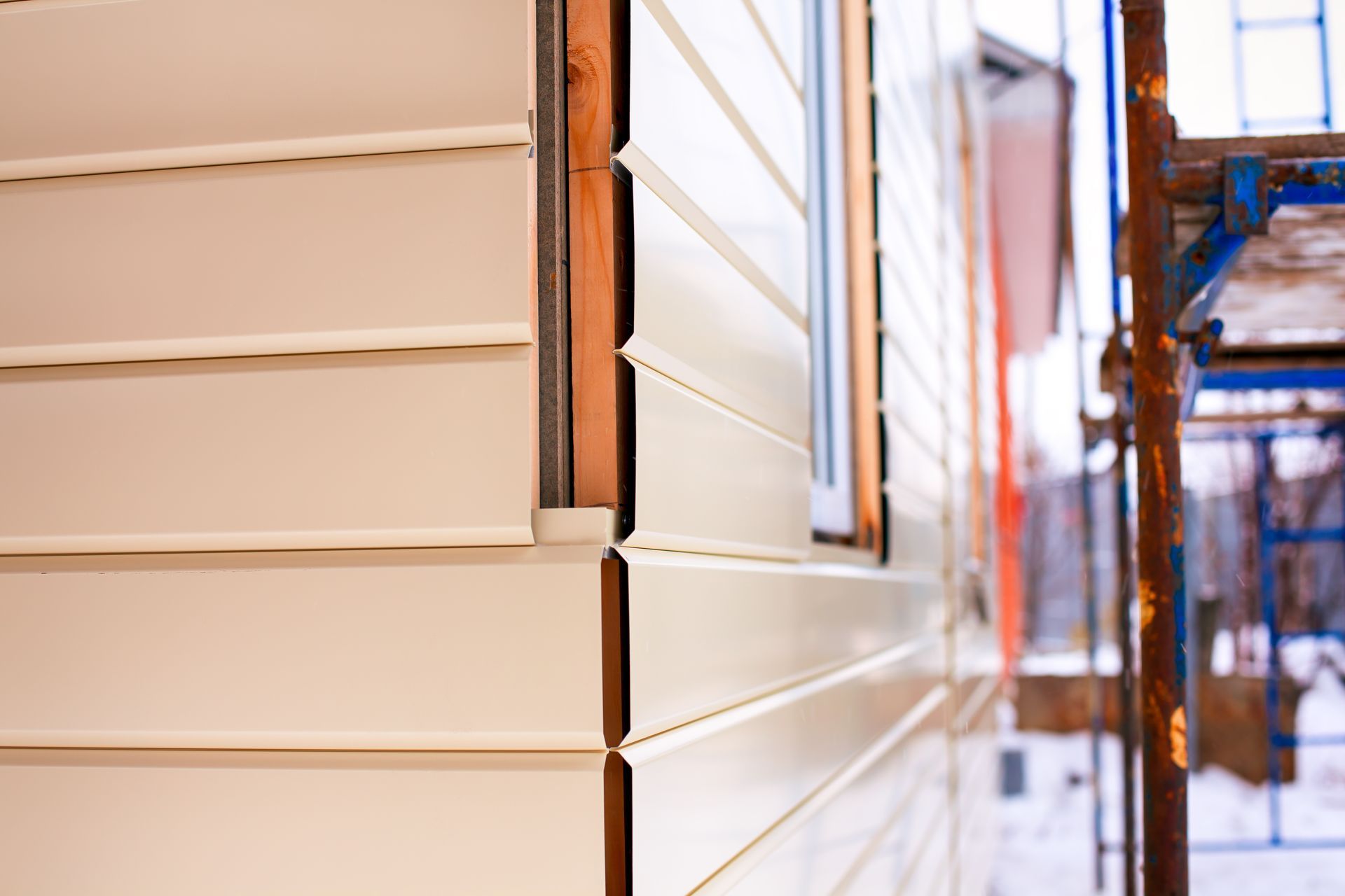 Close-up of horizontal siding panels being installed on a house exterior.