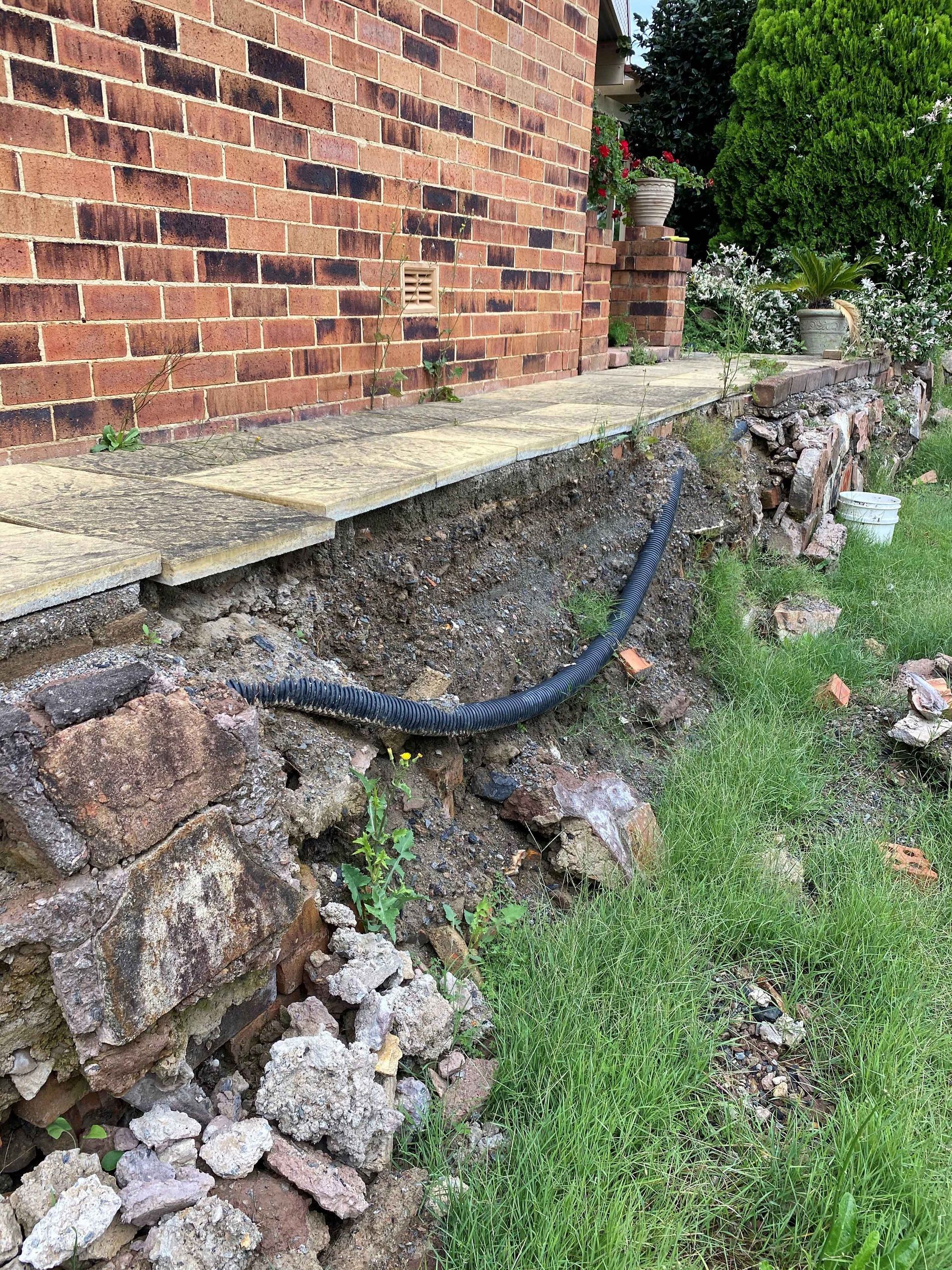 Before Remove Old Retaining Wall & Drainage Issues in residential home in Warners Bay. 