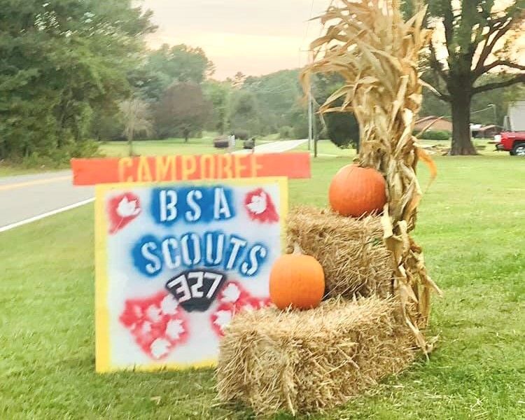 Fall campsite display with “BSA Scouts 327” sign, hay bales, pumpkins, and dried corn stalks
