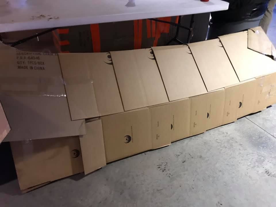 Cardboard box fort built along a wall on a concrete floor in a garage or storage area