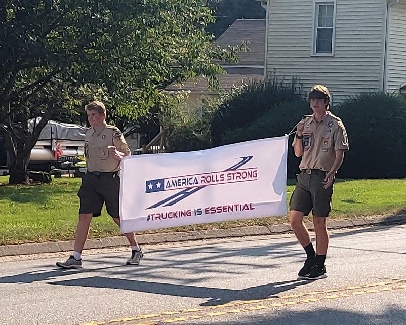 Two people in tan uniforms hold a 