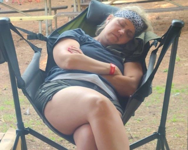 A woman is sleeping in a chair with her legs crossed