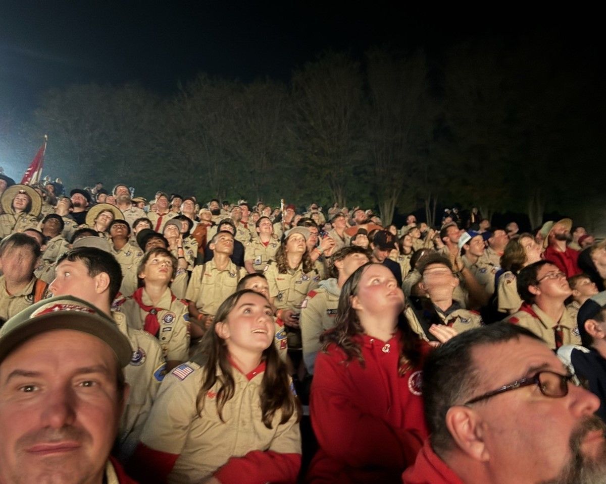 A large group of people are looking up at the sky