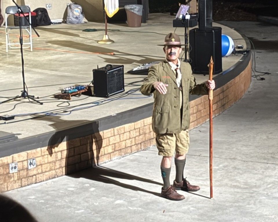 A man standing on a stage holding a cane