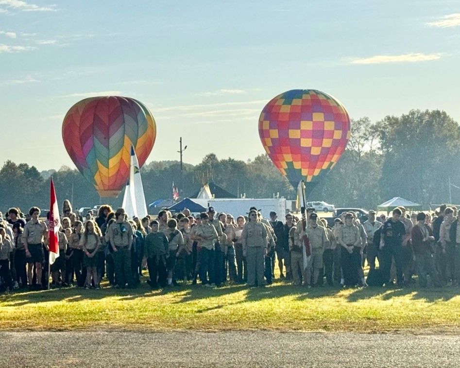 A group of people standing in front of hot air balloons