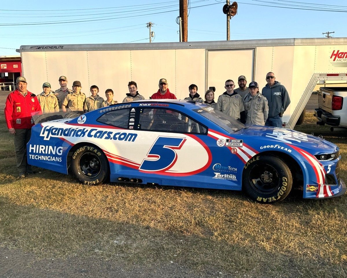 A group of people are standing around a race car.