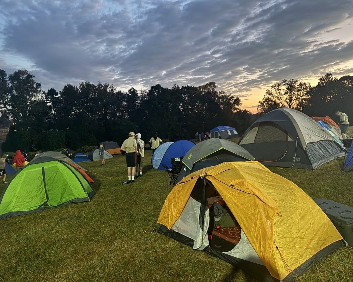 A group of people are camping in a field with tents.