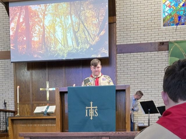 A man stands at a podium with the word ihs on it