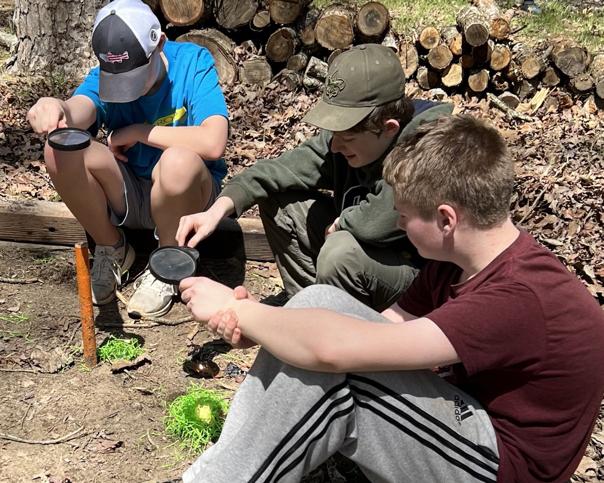 scouts attempting start fires with a magnifying glass