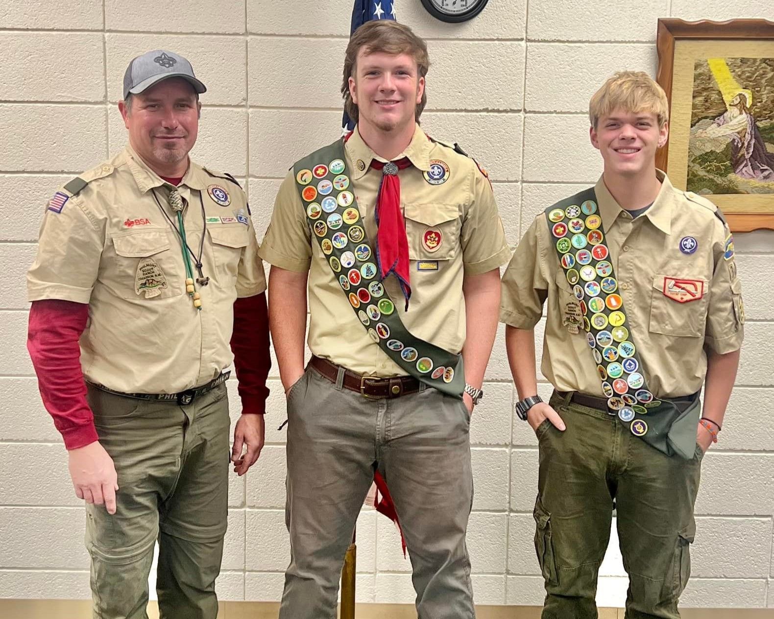 Three boy scouts are posing for a picture together