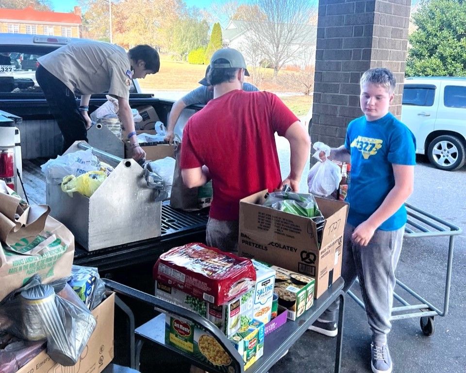 A group of people are loading boxes of food into a truck.