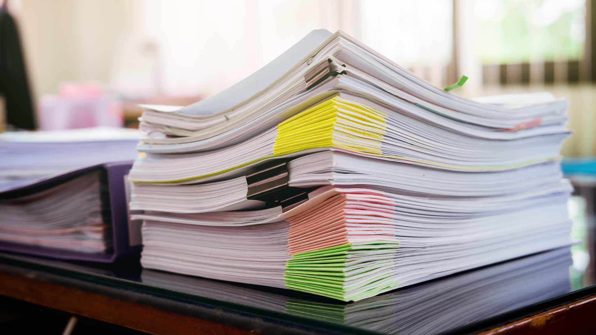 A stack of papers is sitting on top of a desk.