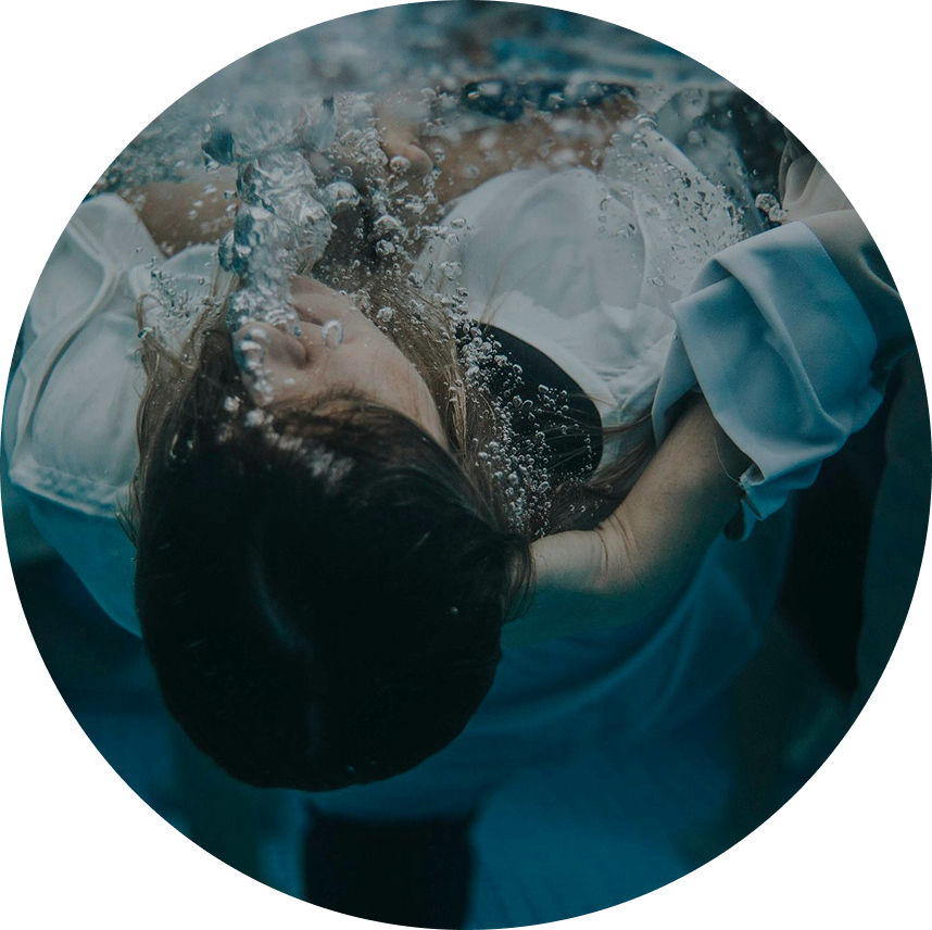 Person floating on water, surrounded by splashing bubbles in a blue pool