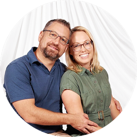Smiling couple posing together against a white studio backdrop