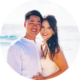Couple smiling in white clothing at a bright beach