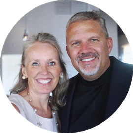 Smiling couple posing indoors, with a softly blurred background