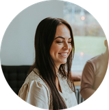 Smiling woman with long dark hair in a bright indoor setting