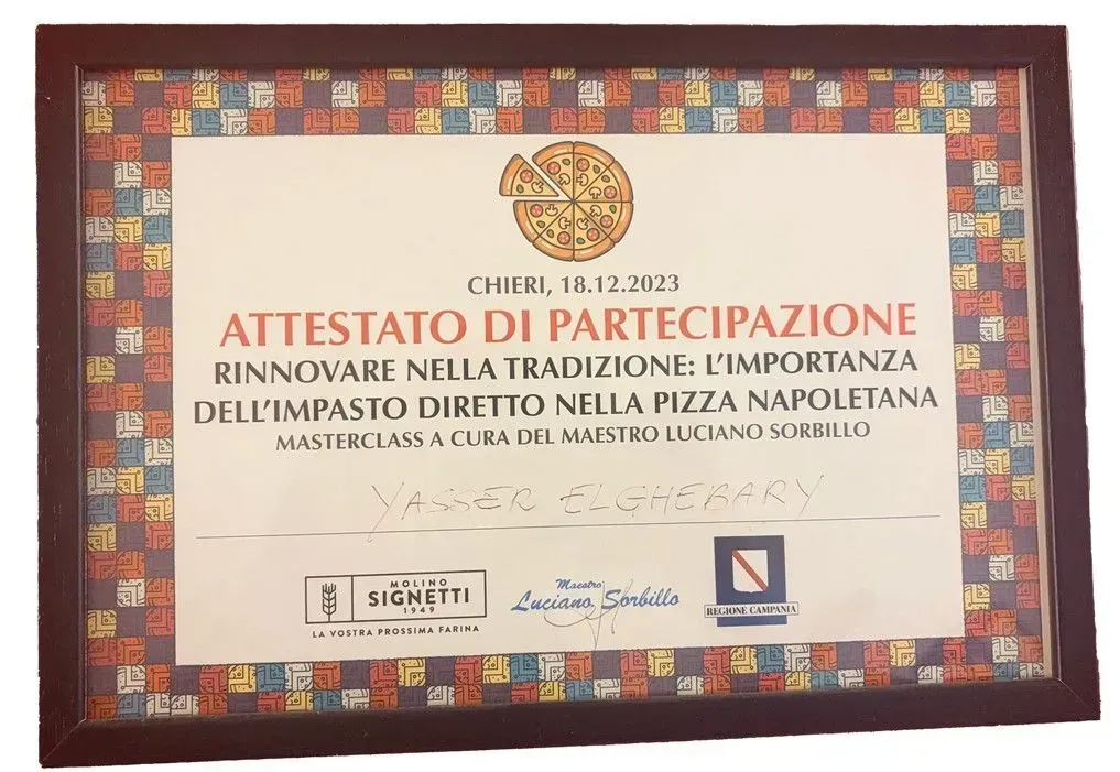 Certificato di premiazione italiano incorniciato con un bordo a mosaico colorato su sfondo bianco.