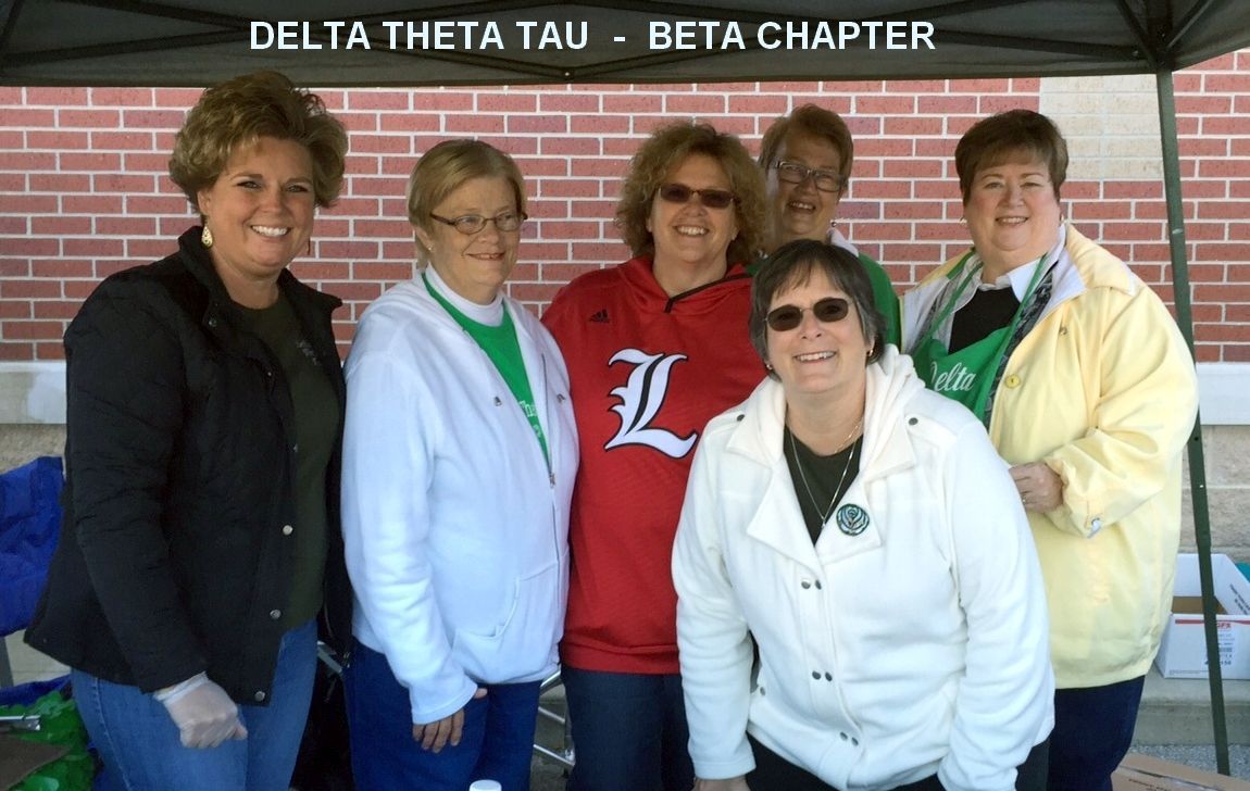 Six members of the Delta Theta Tau Beta Chapter stand under a tent at an outdoor event, smiling toward the camera.