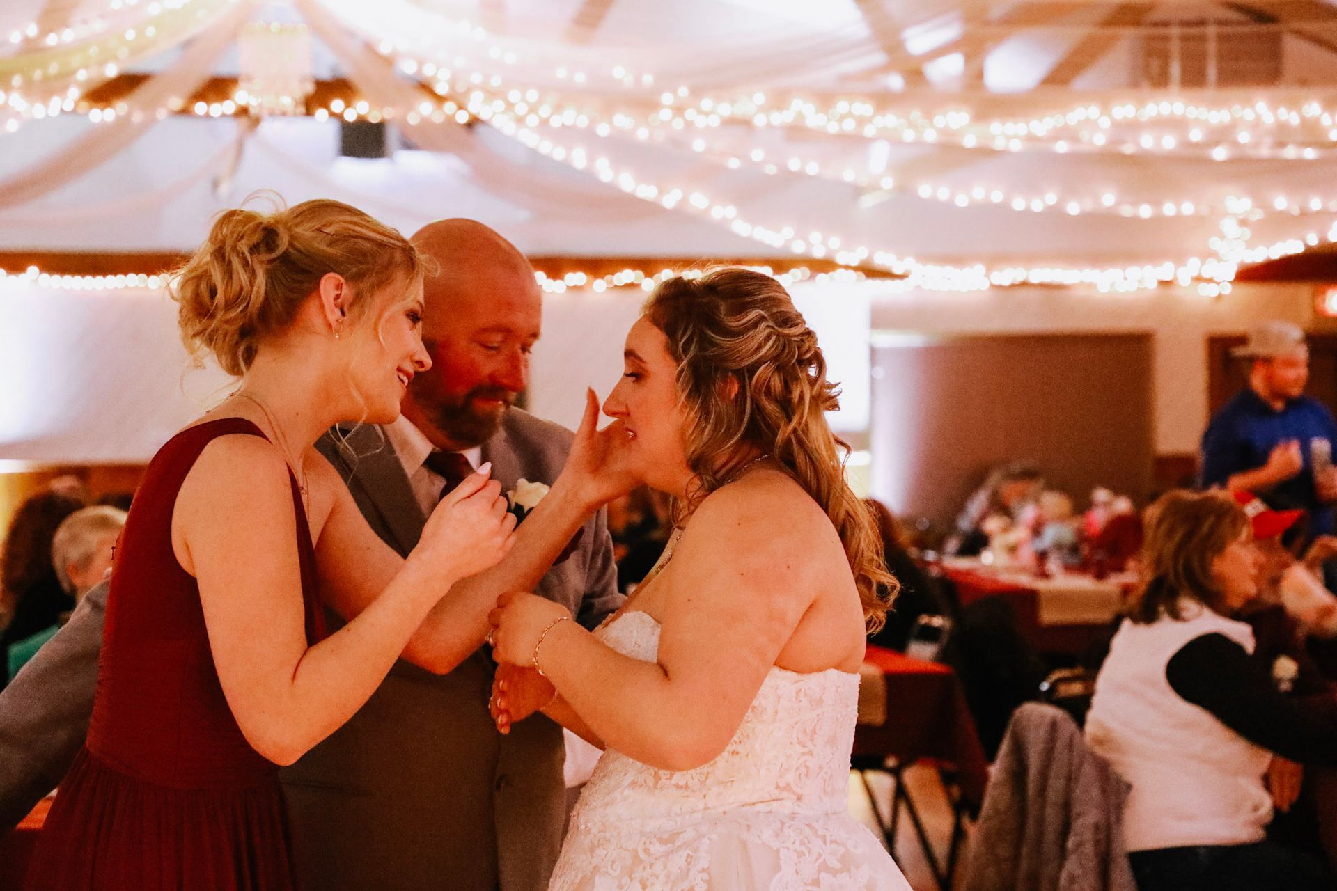 A bride and groom are eating cake together at their wedding reception.