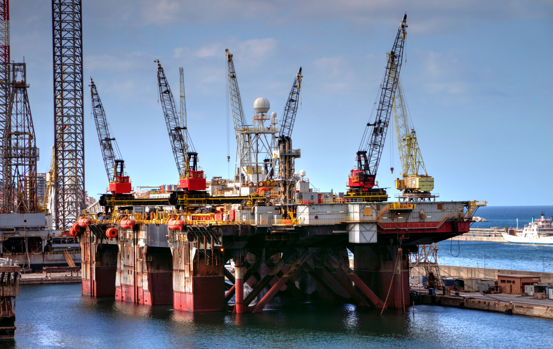 A large oil rig is sitting in the middle of a body of water.
