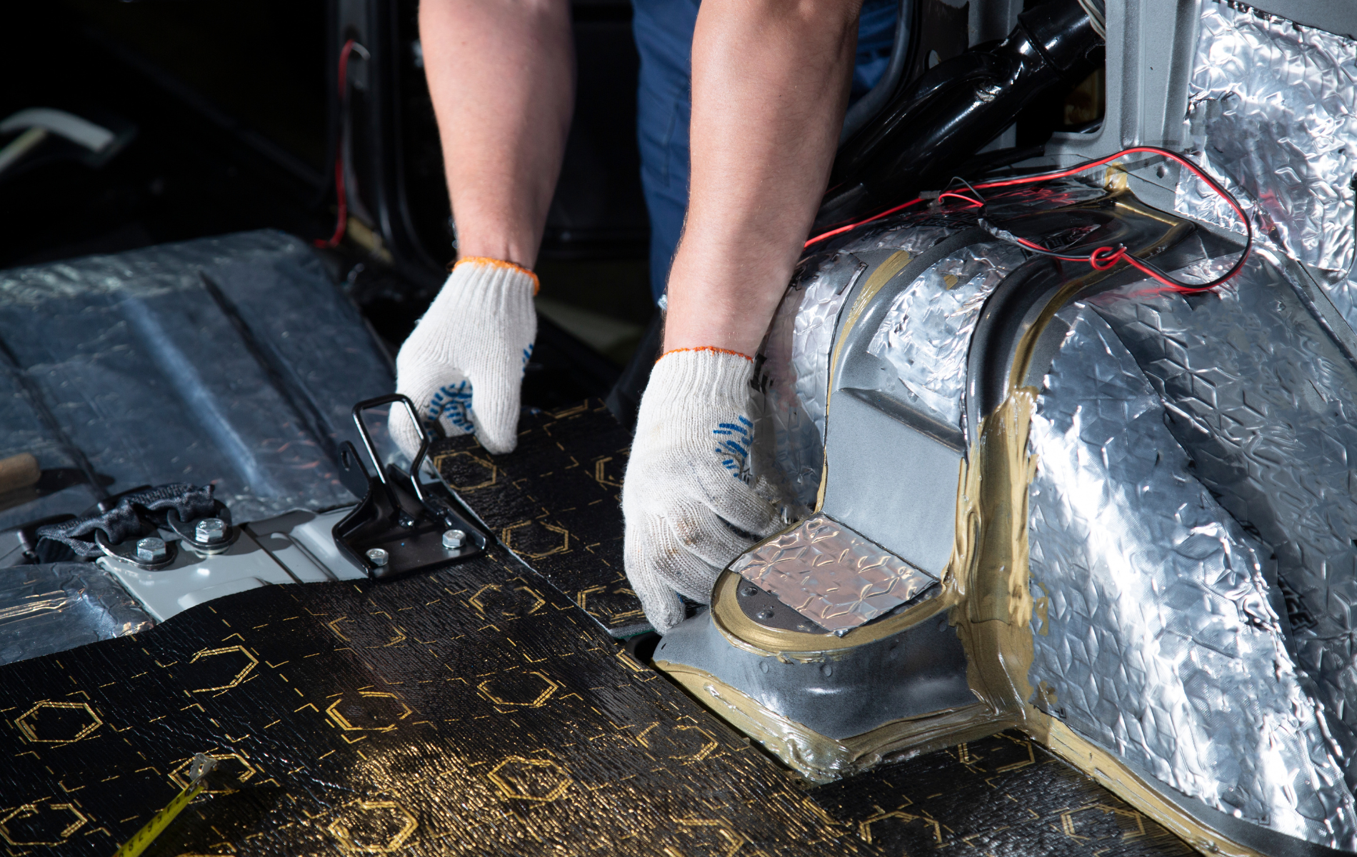 A person is working on a car with a pair of scissors.