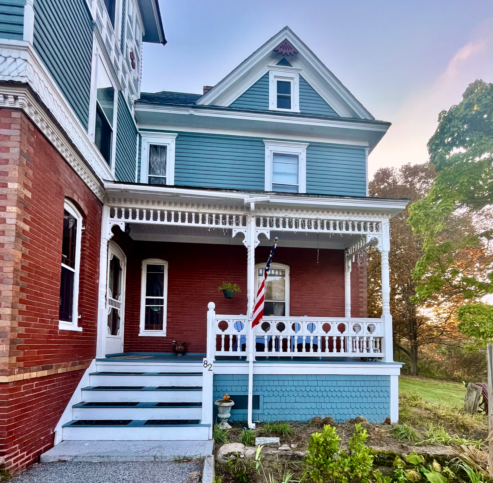 A red brick house with a porch and stairs