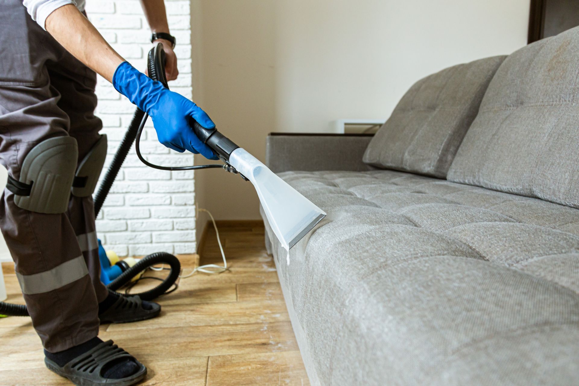 Person Cleaning a Grey Couch With a Vacuum Cleaner — Chemdry D & K in Geelong, VIC