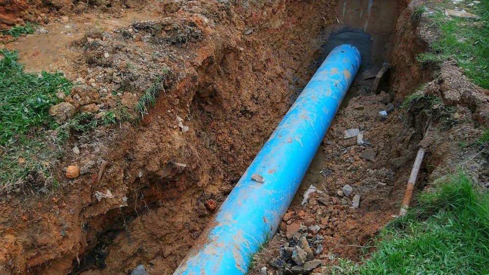 Blue Water Pipe Installed In A Brown Trench — DSR Plumbing Pty Ltd in Cessnock, NSW