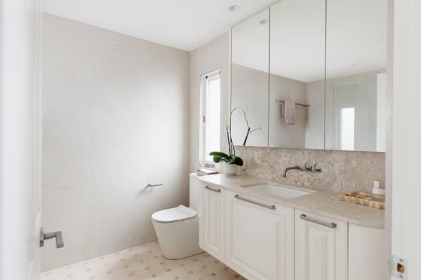 Bright Modern Bathroom With White Vanity, Large Mirror, and Freestanding Toilet — DSR Plumbing Pty Ltd in Ashtonfield, NSW