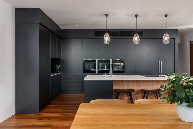 Modern Kitchen With Matte Black Cabinets, White Island, Pendant Lights — DSR Plumbing Pty Ltd in Ashtonfield, NSW