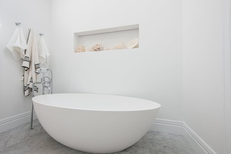 Minimal White Bathroom with A Freestanding Oval Tub and Wall Niche Shelf — DSR Plumbing Pty Ltd in Lake Macquarie, NSW