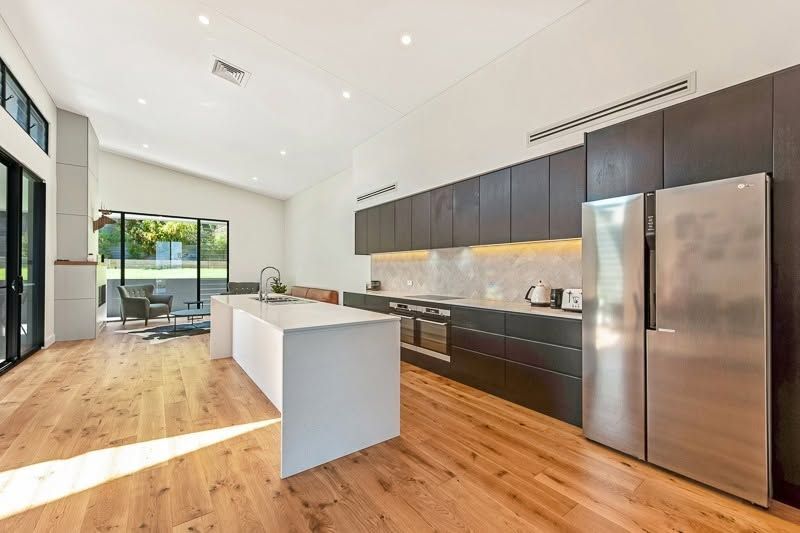 Modern Kitchen With Dark Cabinets, Stainless Steel Appliances, Island — DSR Plumbing Pty Ltd in Ashtonfield, NSW