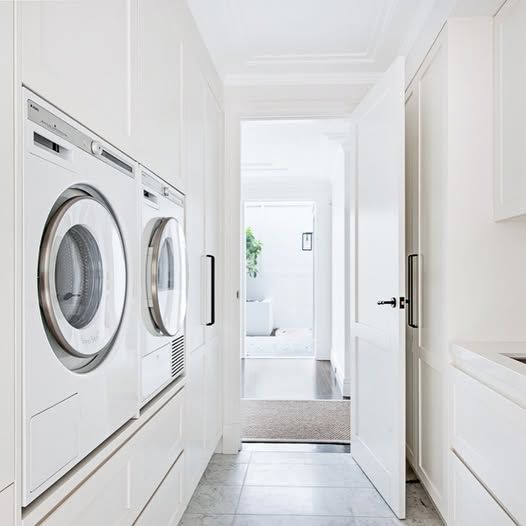 Bright White Laundry Room With Stacked Washer and Dryer — DSR Plumbing Pty Ltd in Ashtonfield, NSW