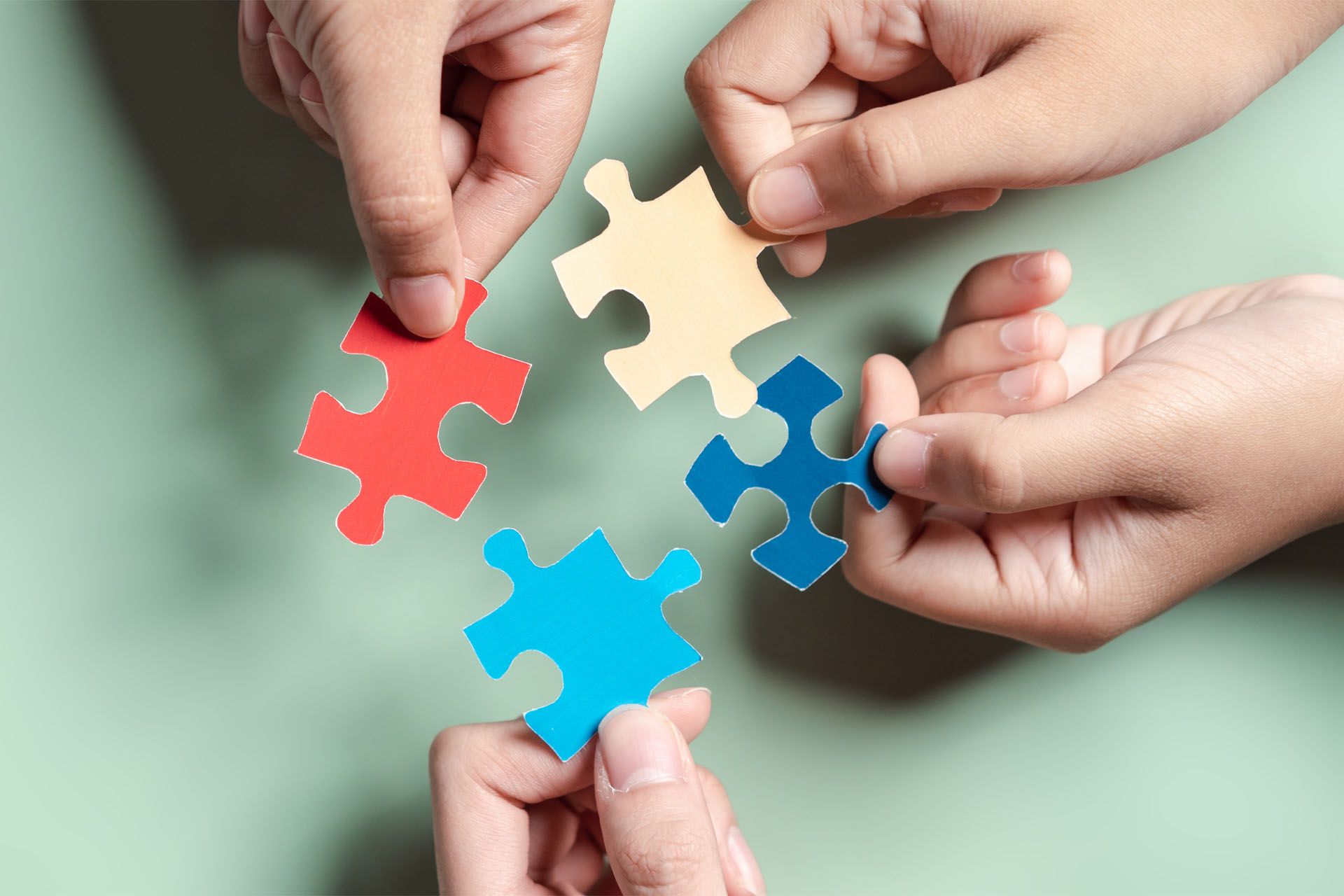 A group of people are putting puzzle pieces together.