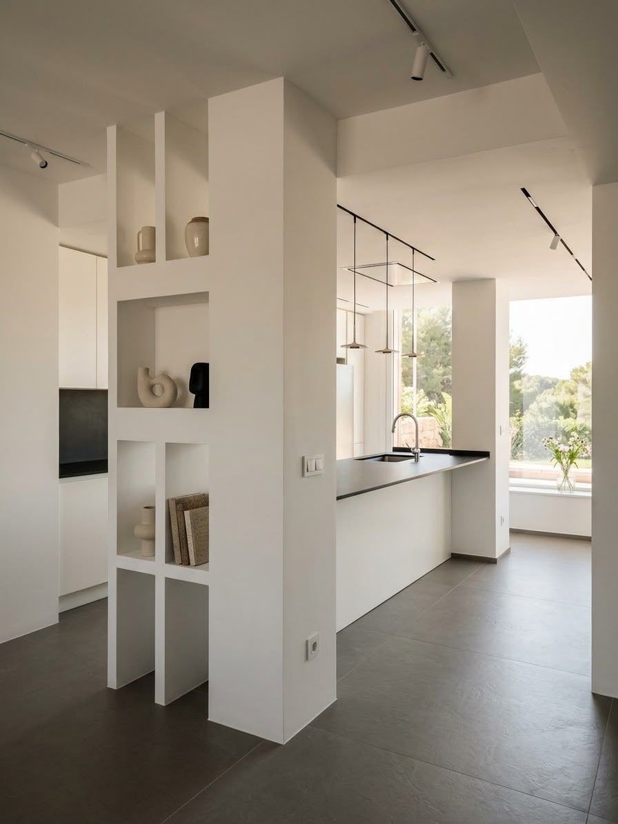 Cucina moderna e luminosa con mensole bianche, piano di lavoro nero e grandi finestre affacciate sul verde