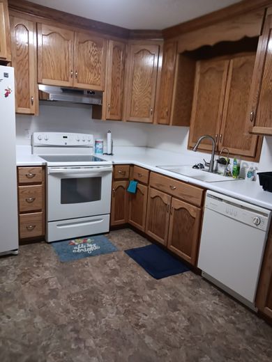 A kitchen under construction with white cabinets and a large island.