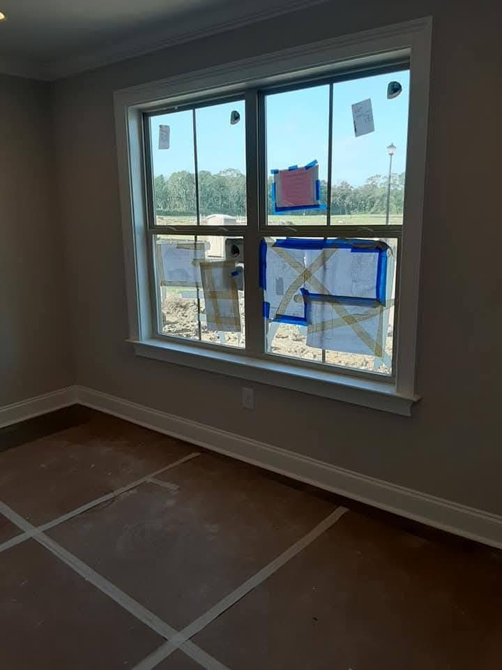 An empty room with a window and tape on the floor.