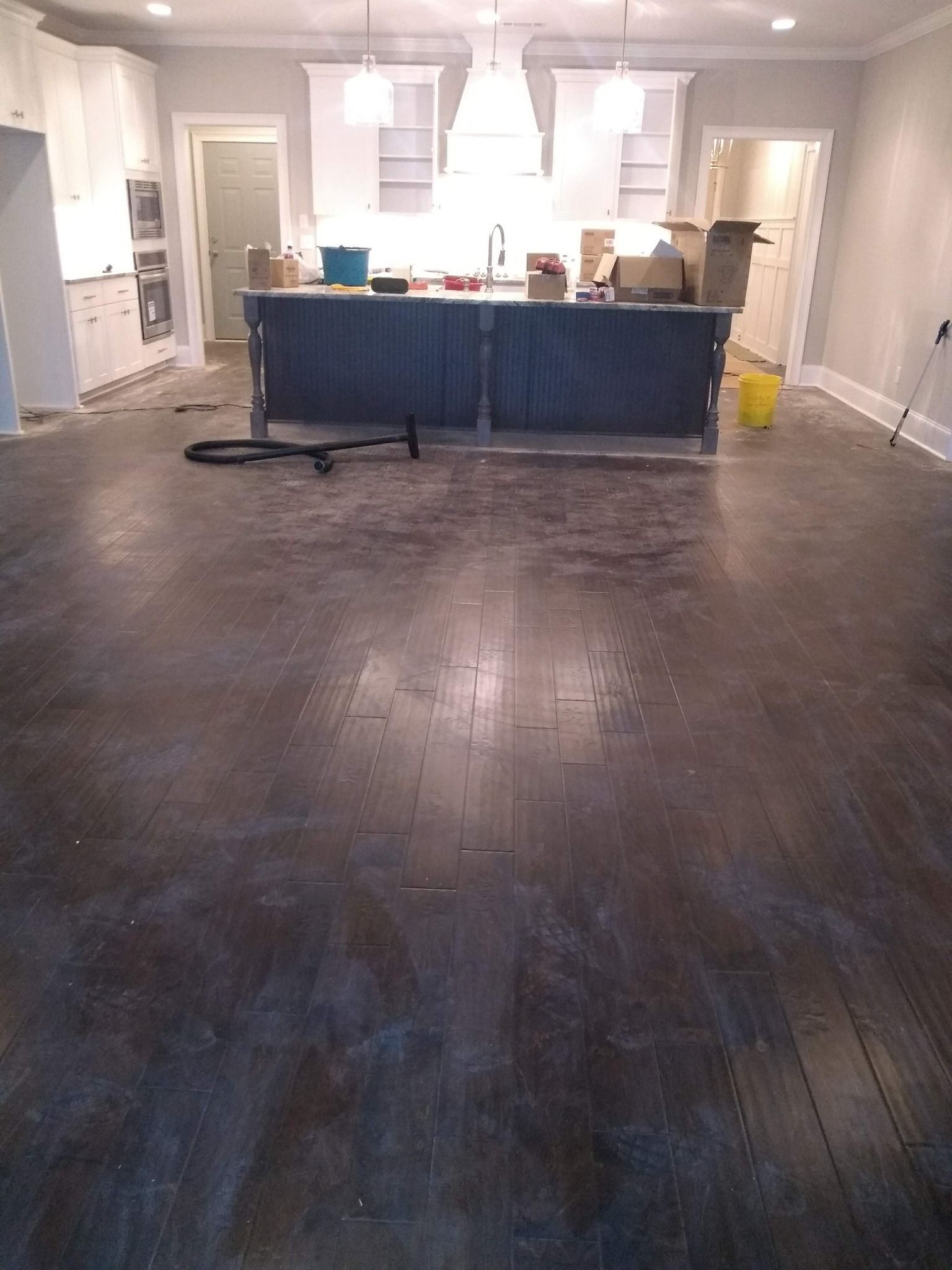 A kitchen with hardwood floors and a large island in the middle of the room.
