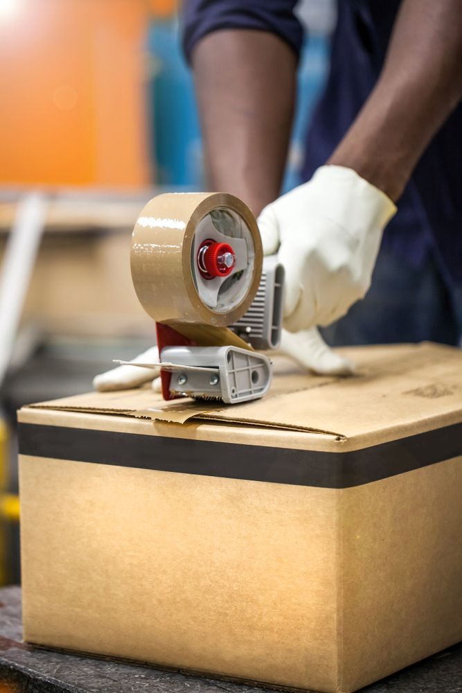 Person Wearing Gloves Sealing a Cardboard — Lite Moves Furniture Removals In Sydney, NSW