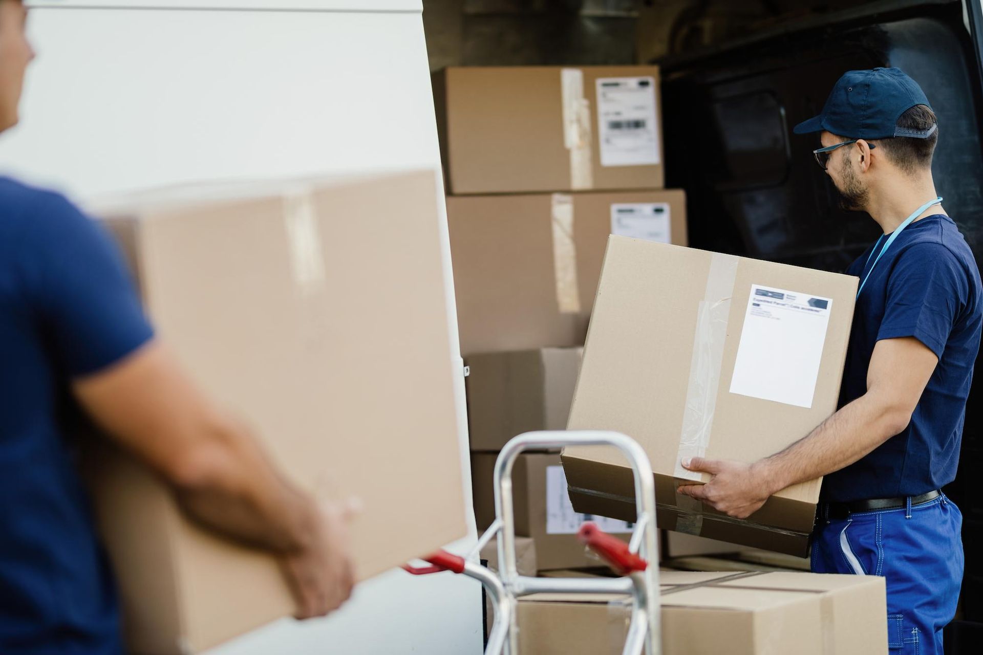 Two Delivery Workers Loading Packages Into a Van — Lite Moves Furniture Removals In Sydney, NSW
