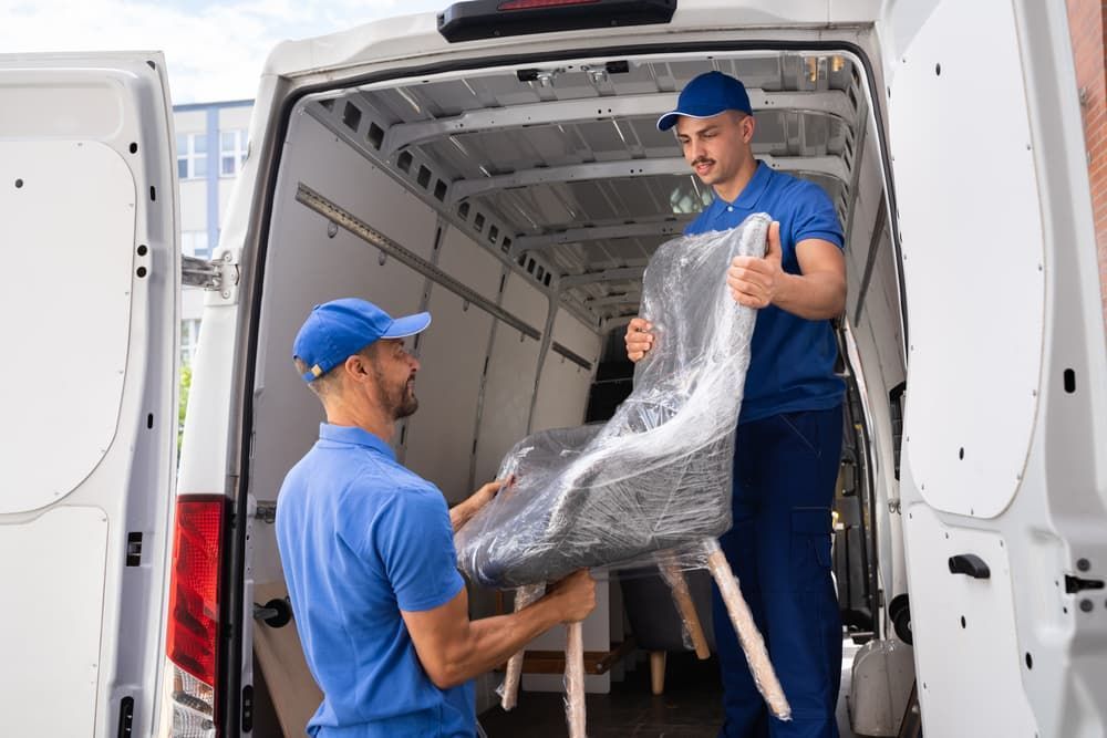 Two Men Are Loading a Chair Into a Van — Lite Moves Furniture Removals In Sydney, NSW