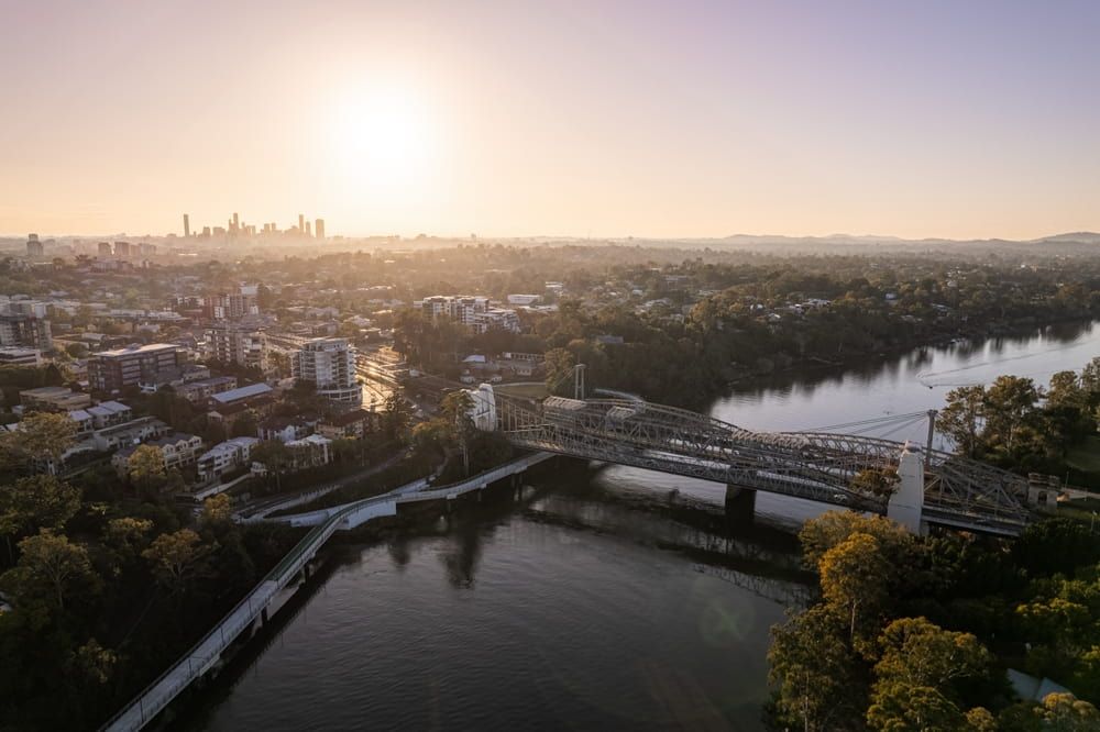 An Aerial View of A Bridge Over a River in A City at Sunset — Lite Moves Furniture Removals In Bonville, NSW