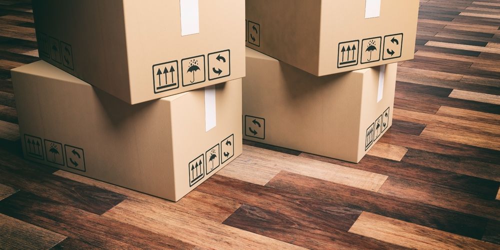 Three Cardboard Boxes Are Stacked on Top of Each Other on a Wooden Floor — Lite Moves Furniture Removals In Sydney, NSW