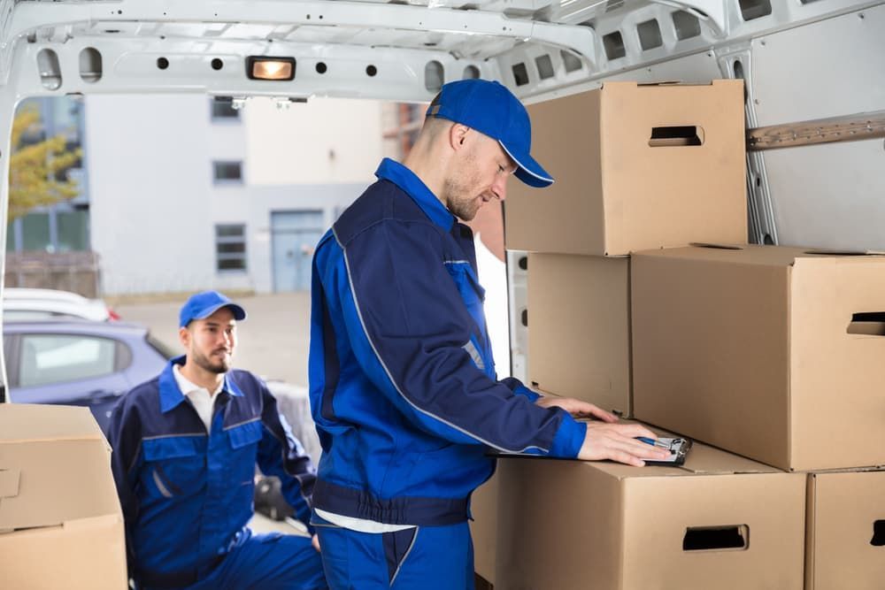Two Men Are Loading Boxes Into a Van — Lite Moves Furniture Removals In Sydney, NSW