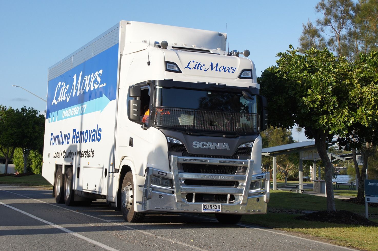 Two Men Move Furniture Carry Sofa For Moving To An Apartment — Lite Moves Furniture Removals In Bonville, NSW